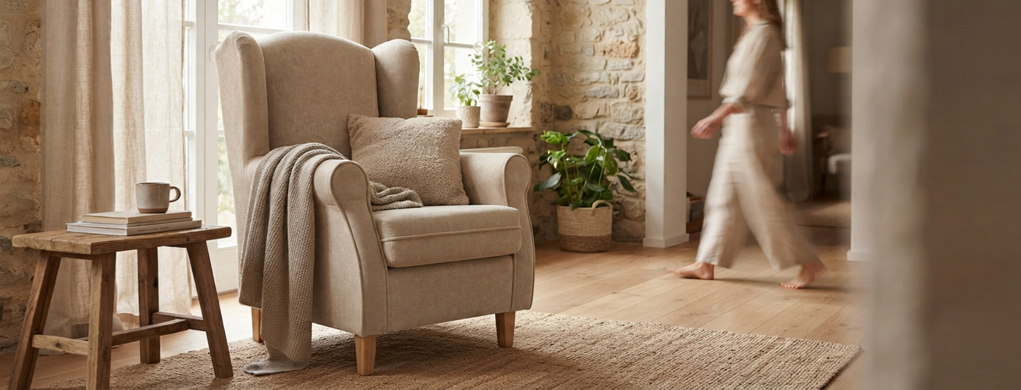 Sillón orejero beige de diseño clásico y acogedor en salón de estilo rústico Sillón orejero tapizado en tela beige con patas de madera clara ubicado en un salón luminoso con decoración cálida